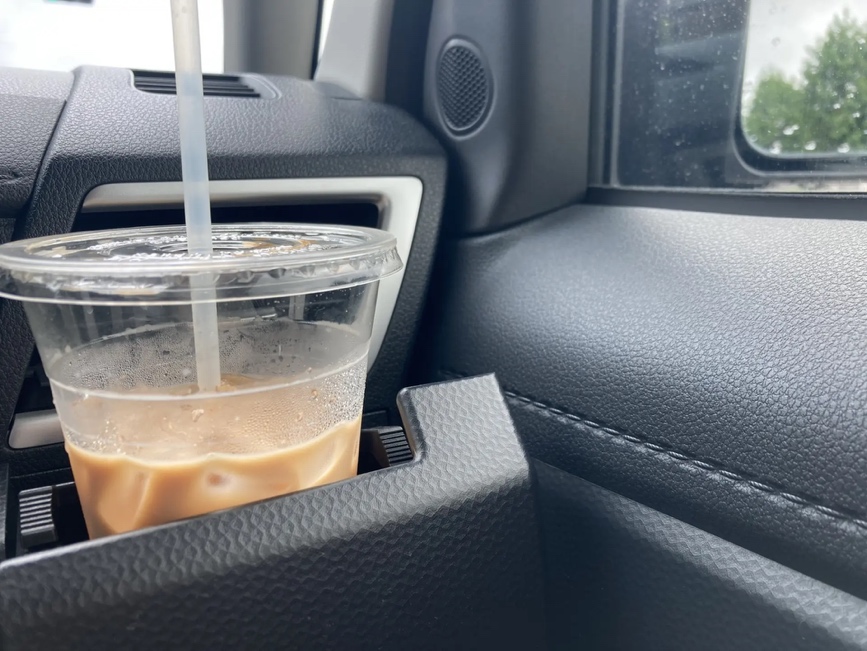 車内のドリンクホルダーに入ったアイスコーヒー