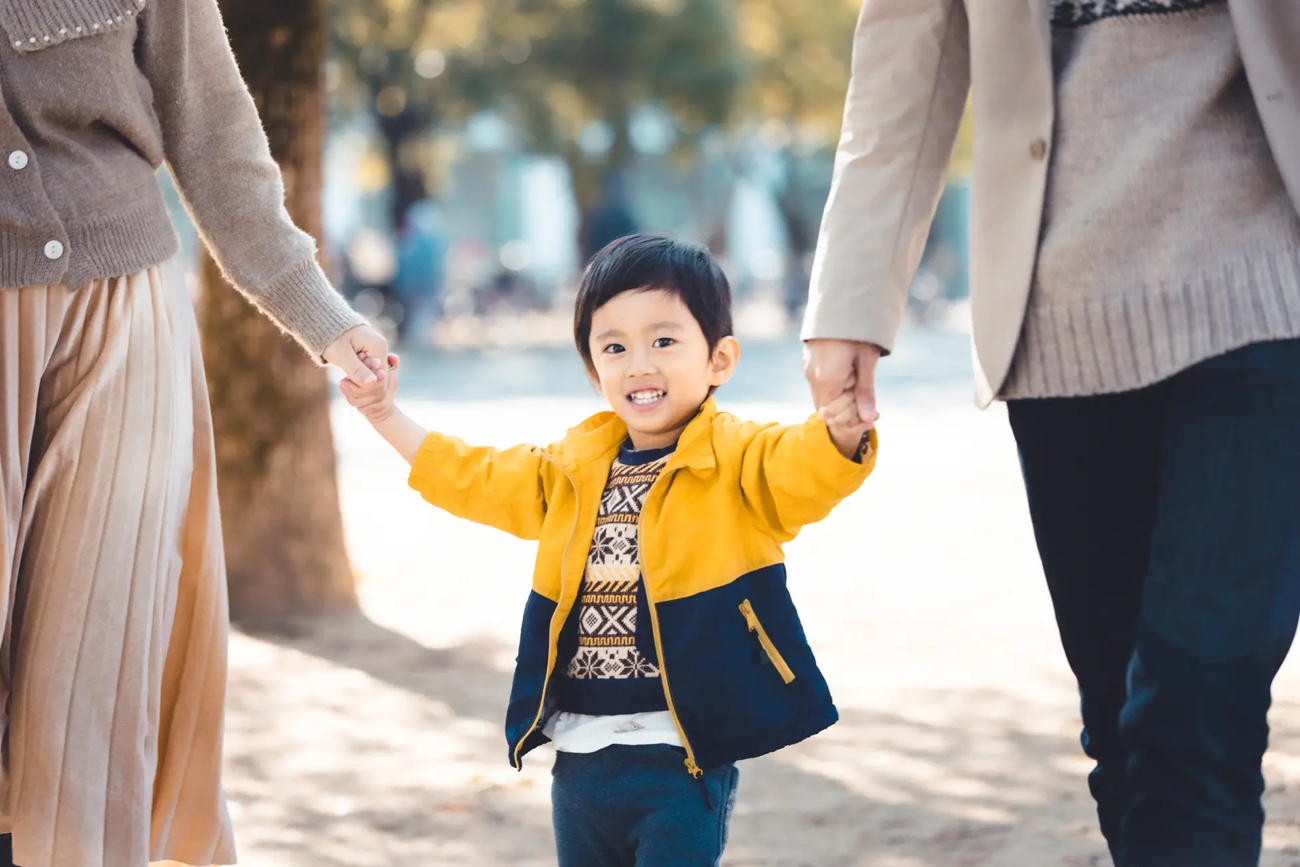 両親に手を引かれ歩く子供