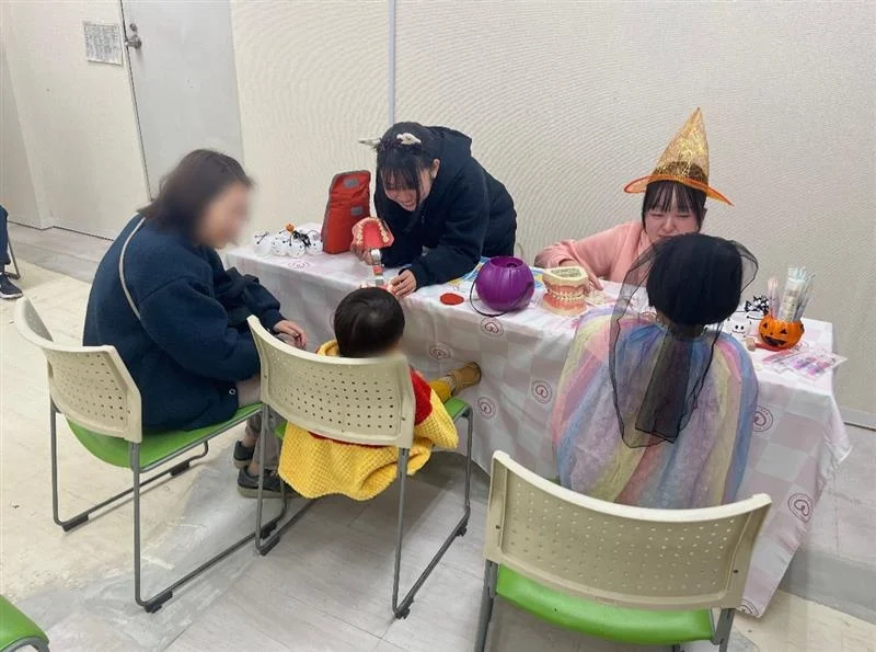 ハロウィンイベントで歯の模型を扱う学生