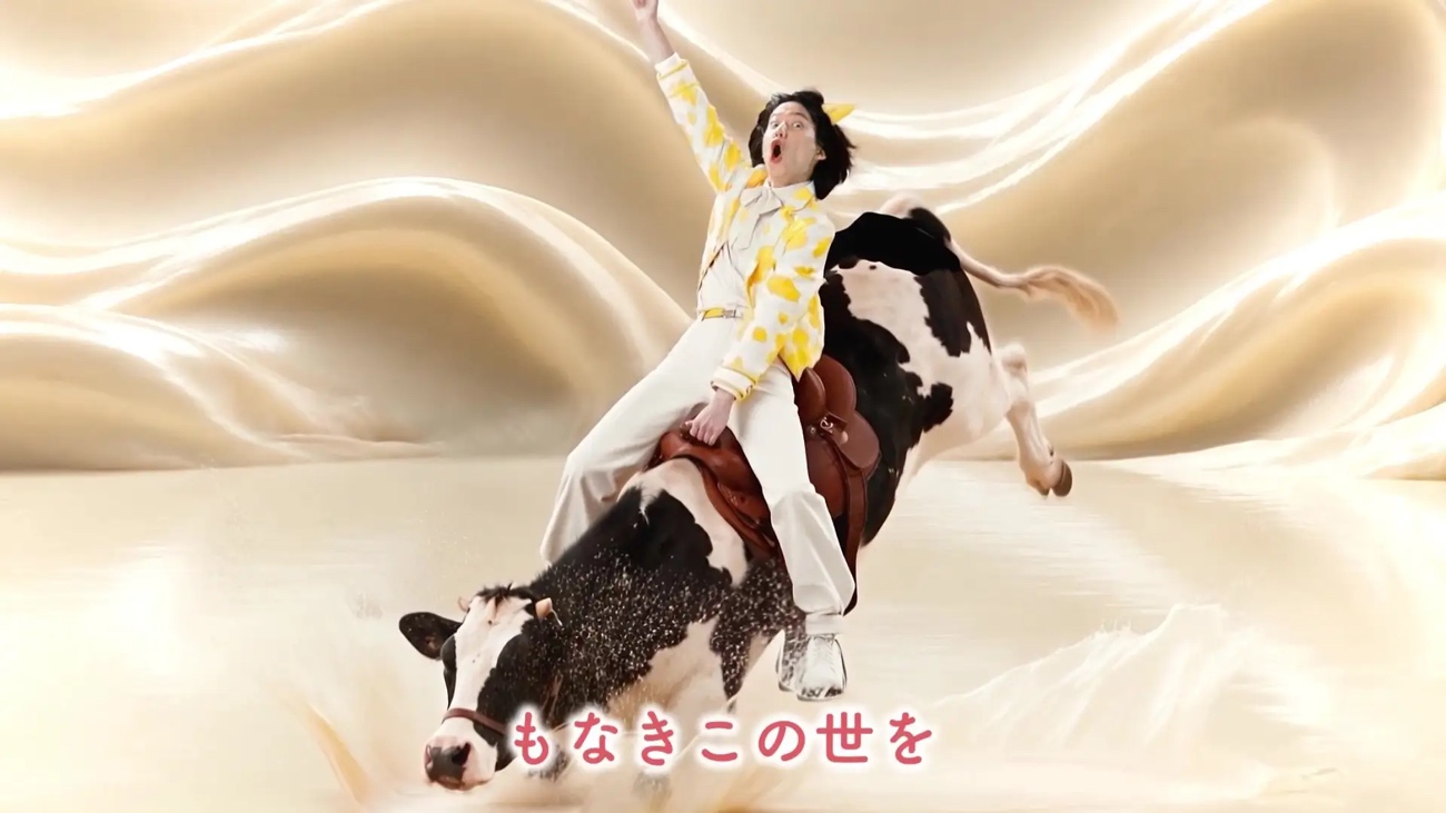 牛柄ジャケットの男性が牛に乗っている