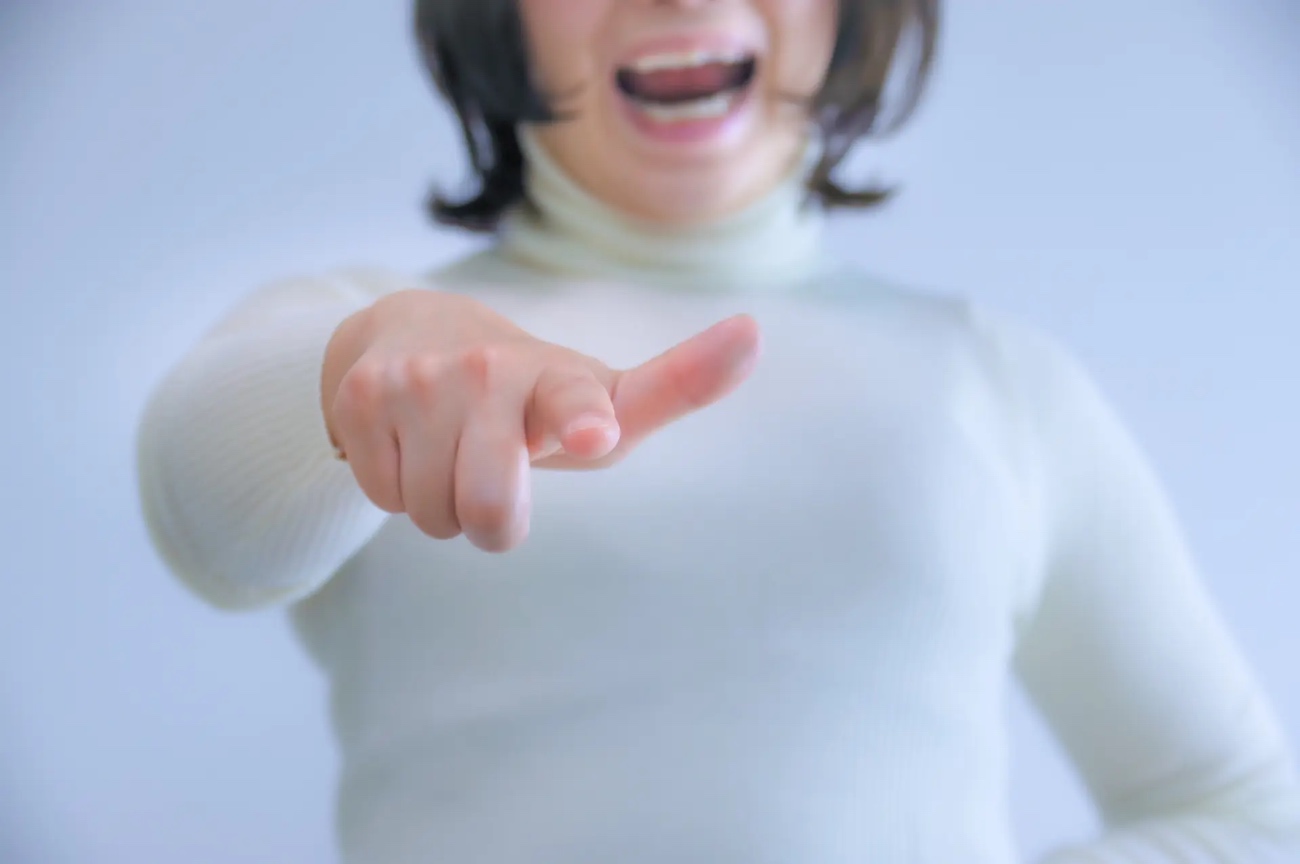 指をさして怒る女性